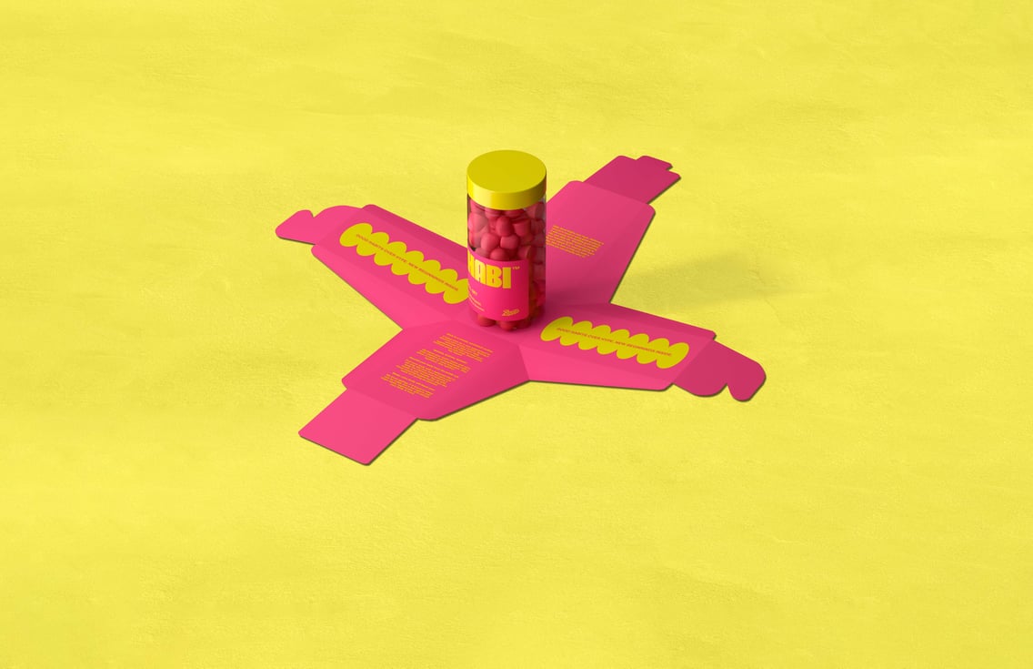 Pink and yellow Boots Habi vitamin gummies jar sitting on its packaging on a yellow stone floor