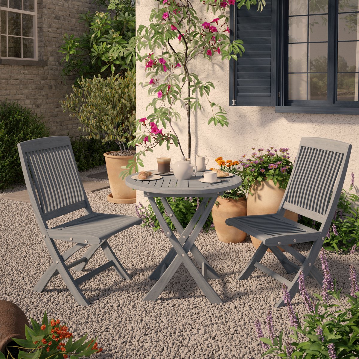 CGI Wooden chairs and table outside on gravel floor next to house with plants